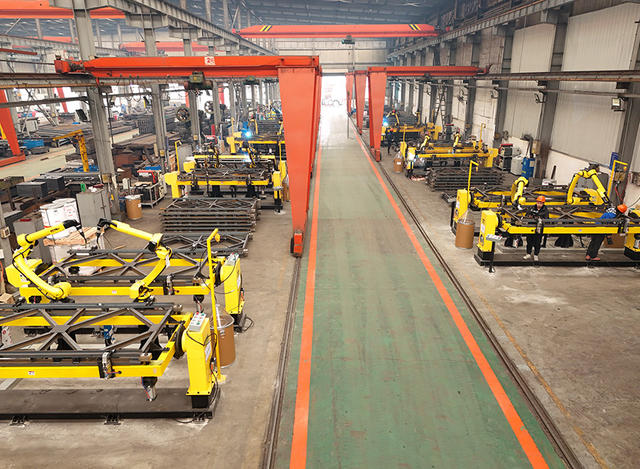 Heavy lifting equipment at a bridge construction site hoisting large bridge components.